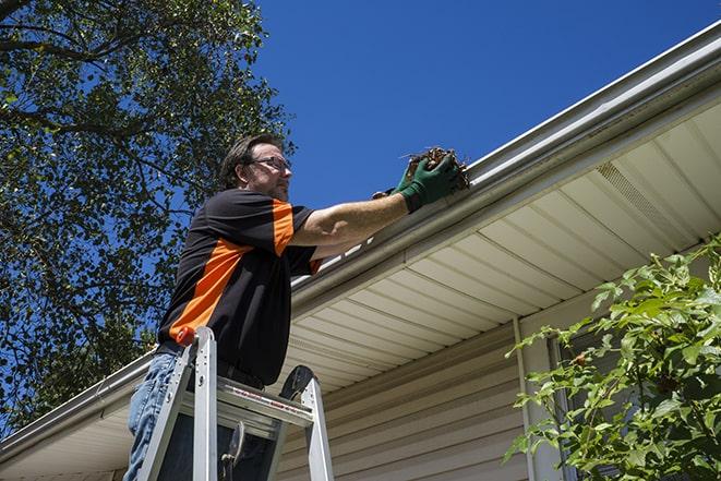 worker installing new gutter system on a roof in East Wenatchee WA